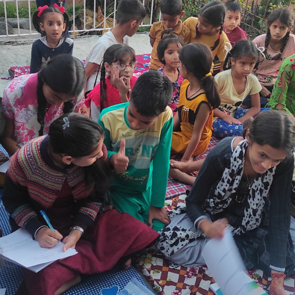Children at the EIF Mohli Learning Hub actively engaged in an English language assessment to track educational progress.