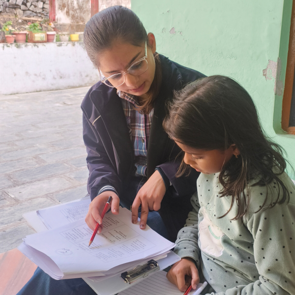EIF Field Associate Diksha Thakur conducting a one-on-one rural learning assessment survey with a student in Parour village, as part of EIF's evidence-based research initiatives.